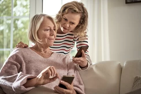 Zwei Frauen schauen ein Smartphone.