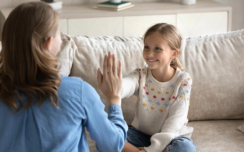 Mutter und kleine Tochter geben sich ein High five.