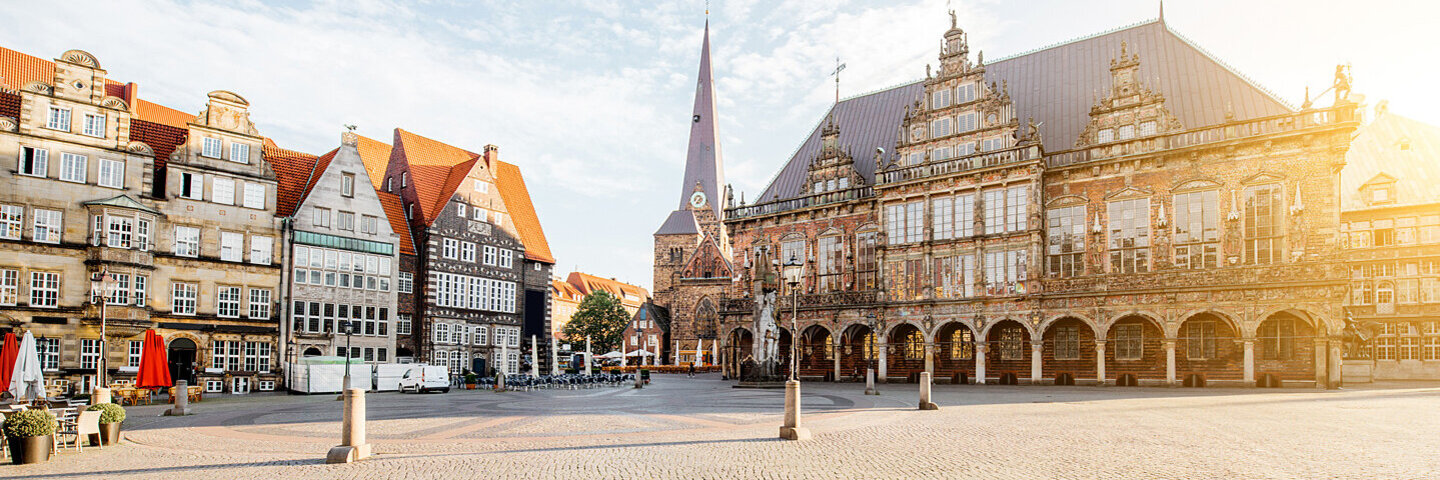 Blick auf den Marktplatz in Bremen mit Rathaus, Kirche und Gebäuden im Morgenlicht.