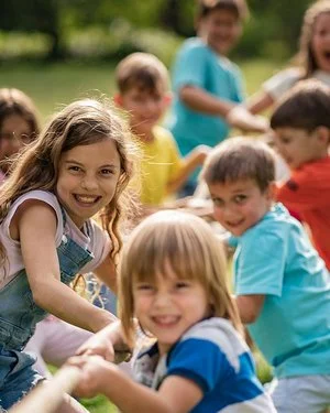 Eine Grundschulklasse spielt im Freien Tauziehen und hat dabei Spaß.