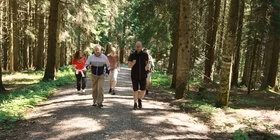 Eine Gruppe älterer Menschen läuft durch den Wald.