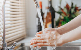 Frau spart kein Wasser und wäscht sich die Hände unter fließendem Wasser.