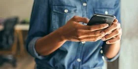 Person tippt auf ihrem Smartphone.