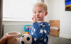 Kleiner Junge popelt in seiner Nase.