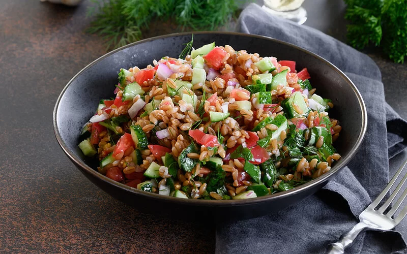 Ein Salat mit Dinkel, Gurke und Tomate.