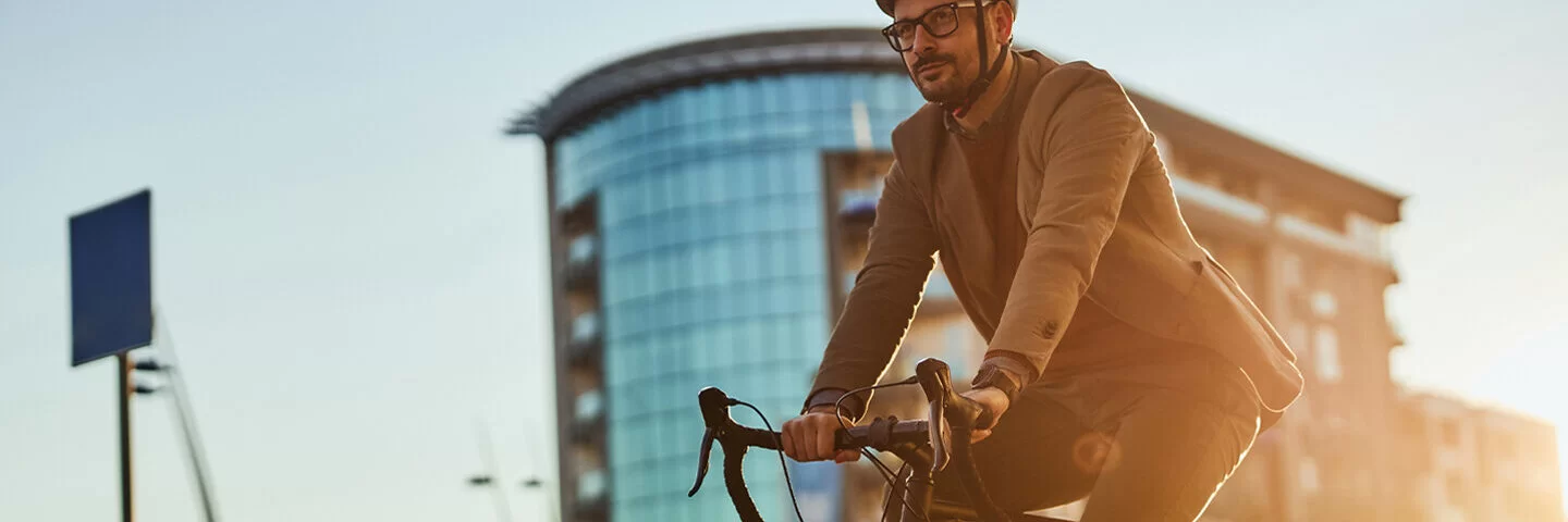 Ein junger Mann mit Helm fährt in der Stadt Fahrrad.