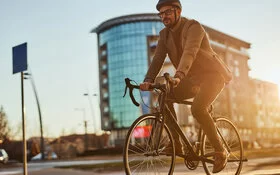 Ein junger Mann mit Helm fährt in der Stadt Fahrrad.