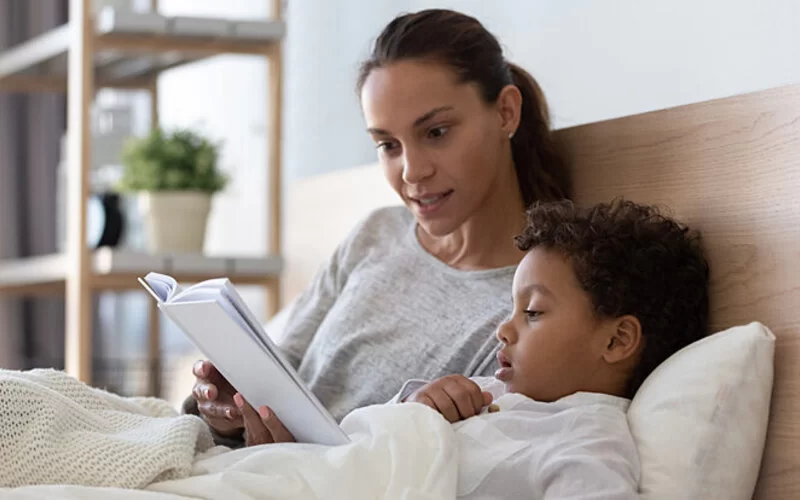 Entspannungstechniken: Mutter liest Kind zur Entspannung vor.
