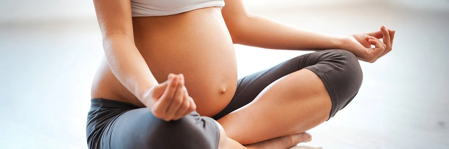 Eine schwangere Frau macht Yoga.