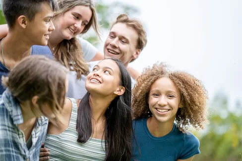Eine Gruppe Teenager, die draußen zuzsammen ihre Freizeit verbringen.