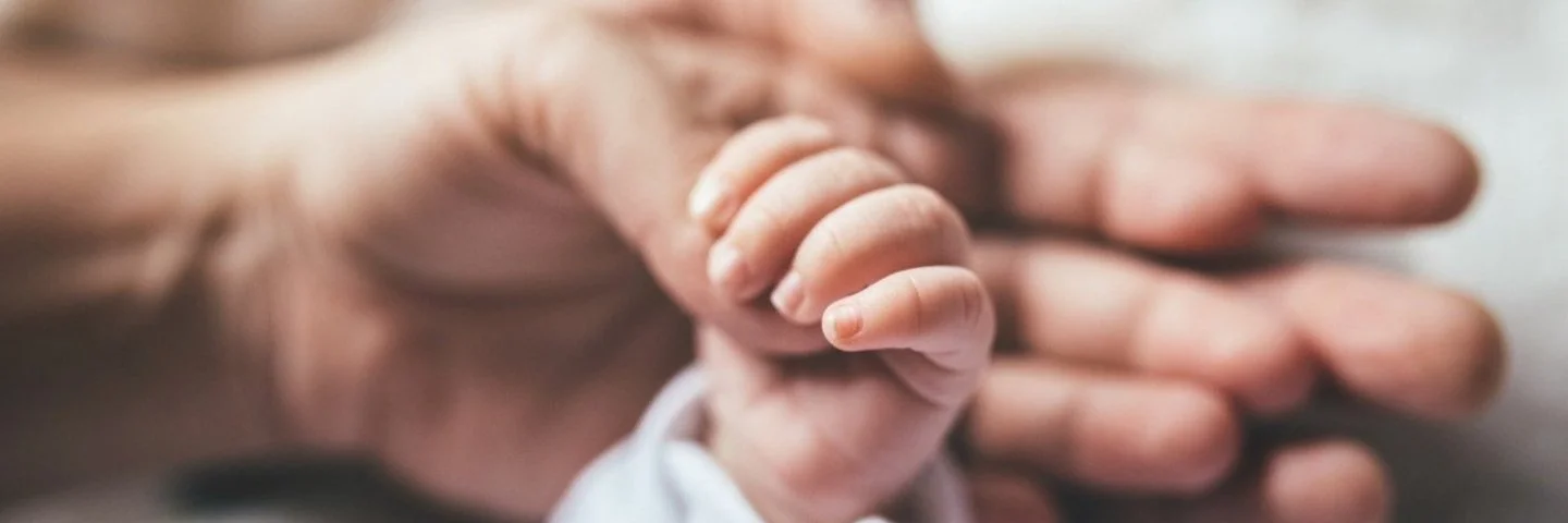 Mutter hält Hand des Babys