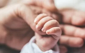 Mutter hält Hand des Babys