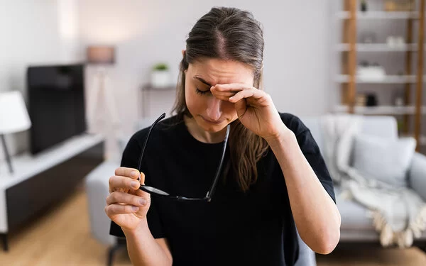 Eine Frau reibt sich die müden Augen.