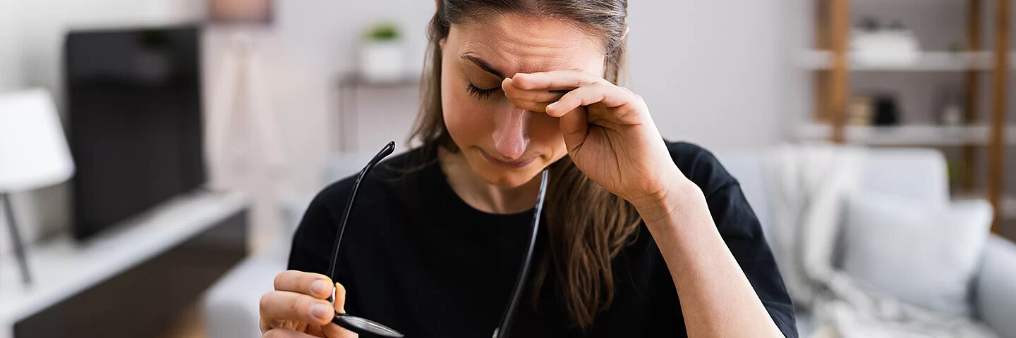 Eine Frau reibt sich die müden Augen.