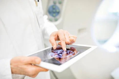 Künstliche Intelligenz: Tablet zeigt medizinischen Content, wird in zwei Händen gehalten.