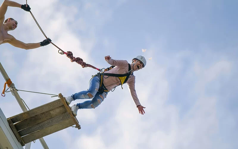 Eine junge Frau kurz vorm Absprung beim Bungee-Jumping.