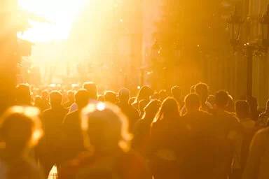 Eine Fußgängerzone mit einer Menschenmenge in der Abendsonne.