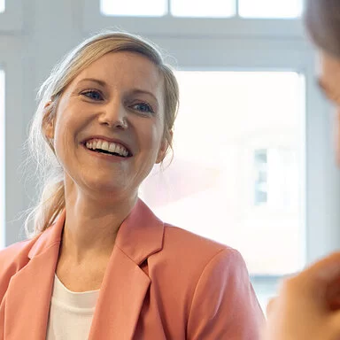 Zwei gut gelaunte Frauen sprechen miteinander. Als Berufseinsteigerinnen sind sie bei der AOK gut versichert.