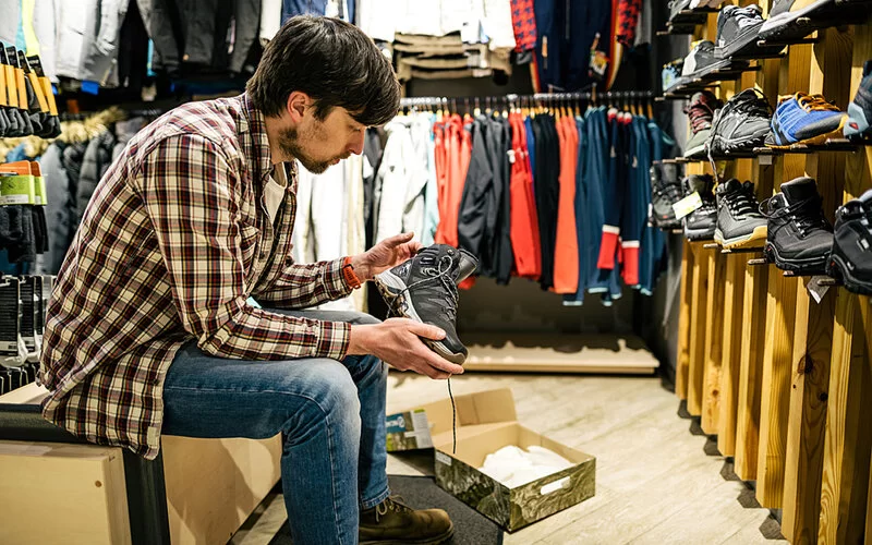 Ein Mann probiert Wanderschuhe in einem Schuhgeschäft an.