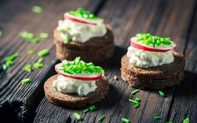 Nahaufnahme von Sandwich mit Pumpernickelbrot, Schnittlauch und Hüttenkäse