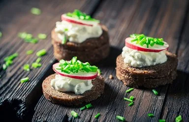 Nahaufnahme von Sandwich mit Pumpernickelbrot, Schnittlauch und Hüttenkäse