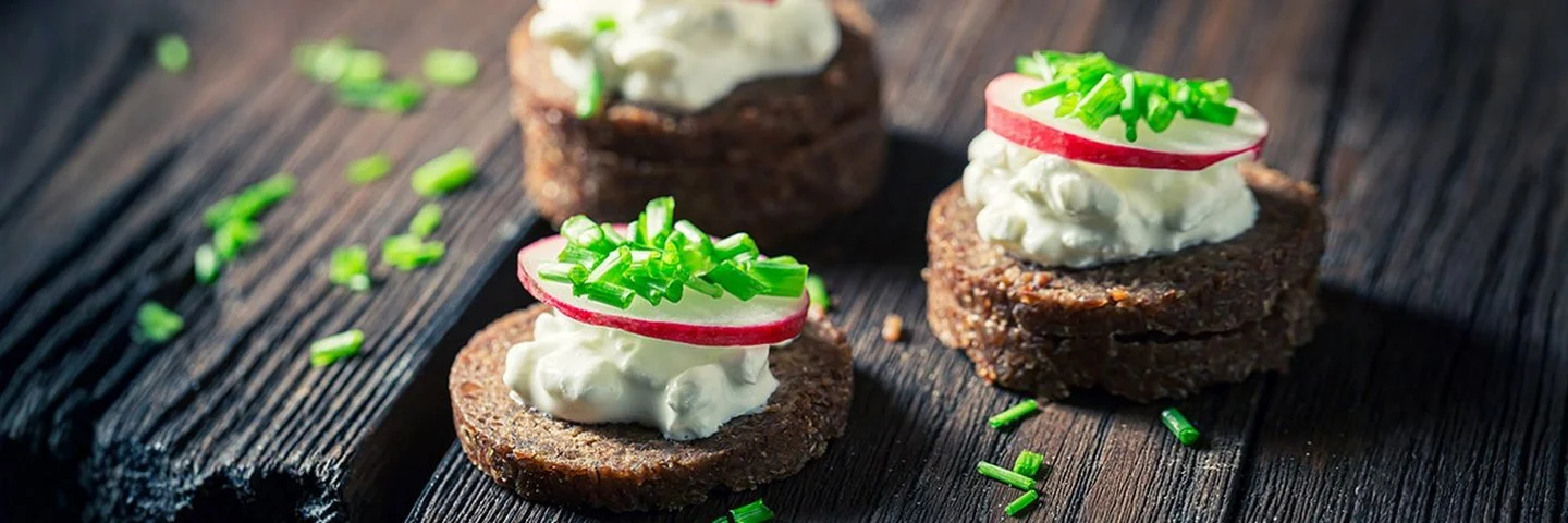 Nahaufnahme von Sandwich mit Pumpernickelbrot, Schnittlauch und Hüttenkäse