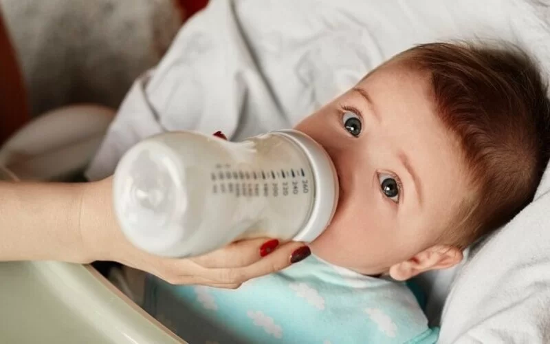 Ein Baby trinkt aus einer sterilisierten Babyflasche.