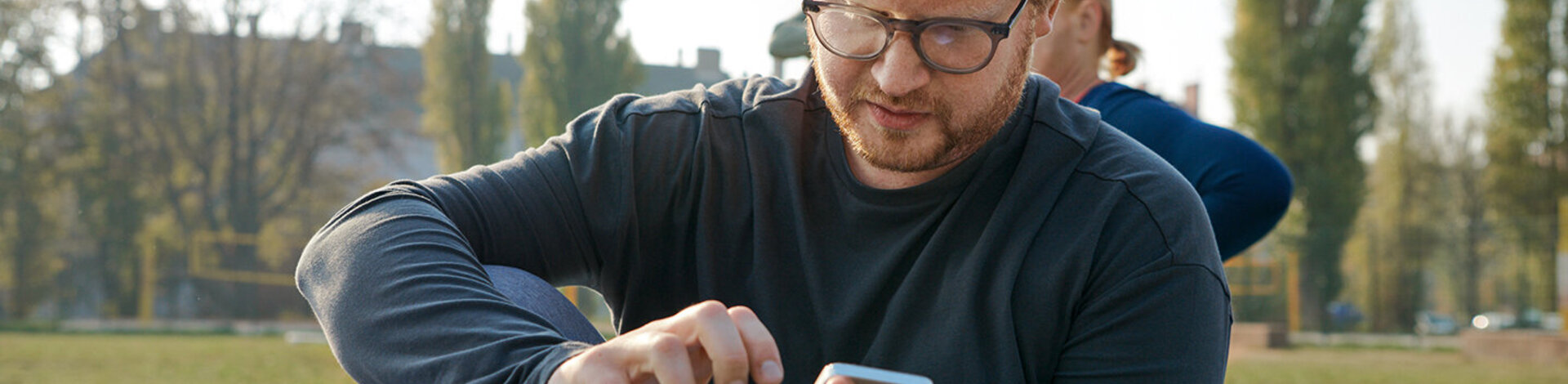 Ein jüngerer Mann recherchiert mit seinem Smartphone. Barrierefreie Angebote der AOK erleichtern den Zugriff.
