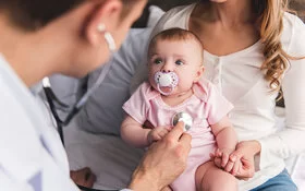 Junge Mutter besucht mit ihrem Baby einen Kinderarzt.