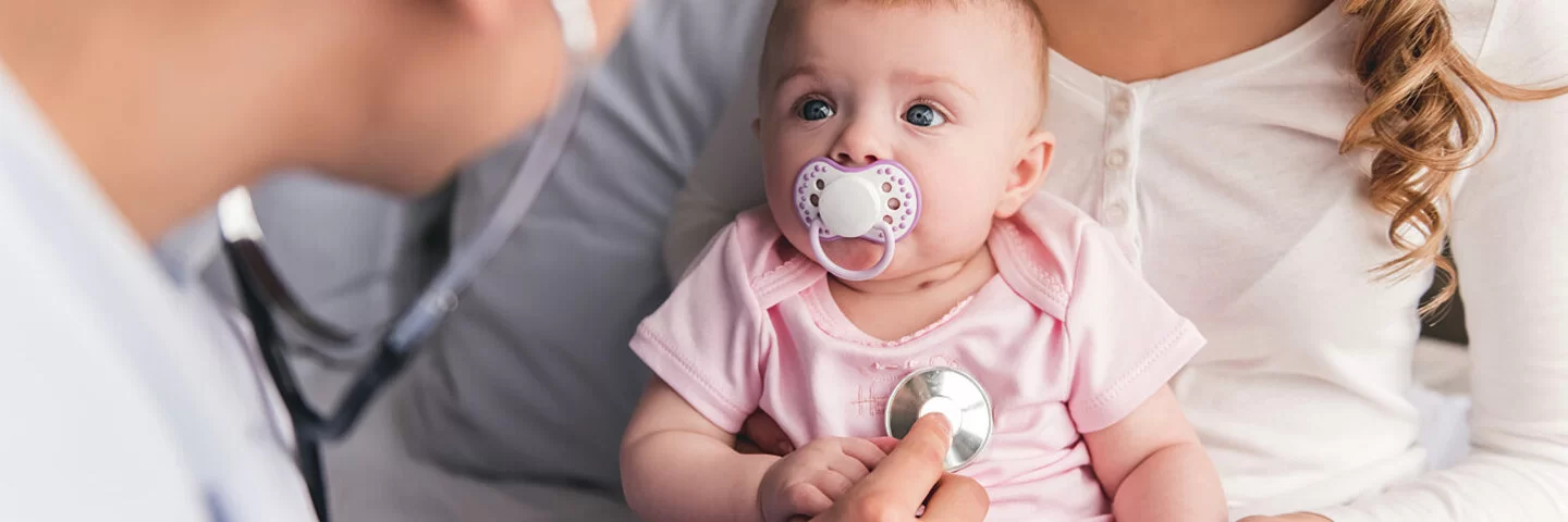 Junge Mutter besucht mit ihrem Baby einen Kinderarzt.