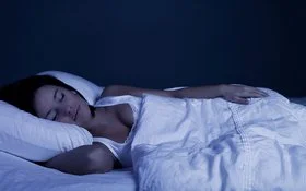 Junge Frau schläft ruhig in ihrem Bett