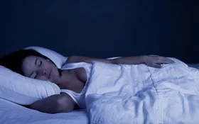 Junge Frau schläft ruhig in ihrem Bett