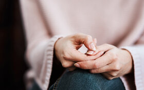 Eine Frau reibt sich nervös die Finger – sie leidet unter innerer Unruhe.