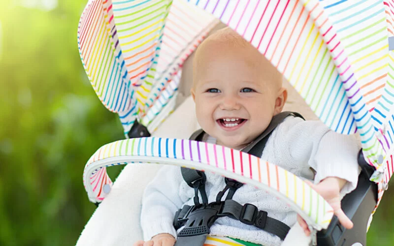 Baby liegt im Kinderwagen und so vor der Sonne geschützt.