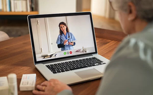 �Ältere Dame nutzt Telemedizin und tauscht sich mit ihrer Ärztin via Videosprechstunde aus.