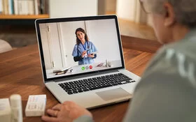 Ältere Dame nutzt Telemedizin und tauscht sich mit ihrer Ärztin via Videosprechstunde aus.