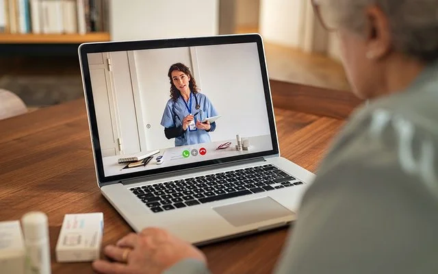 Ältere Dame nutzt Telemedizin und tauscht sich mit ihrer Ärztin via Videosprechstunde aus.