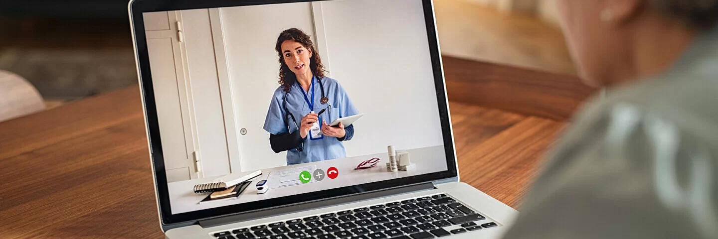 Ältere Dame nutzt Telemedizin und tauscht sich mit ihrer Ärztin via Videosprechstunde aus.