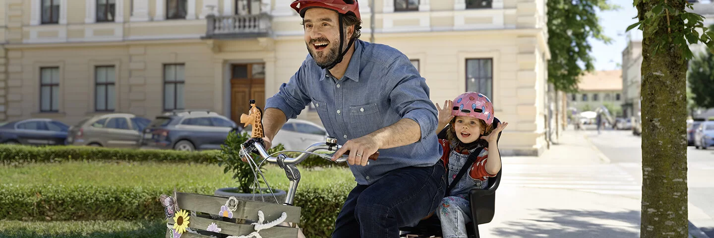 Fröhlicher Mann mit Kind auf dem Fahrrad