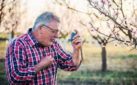 Ein Mann mit Asthma benutzt seinen Inhalator.