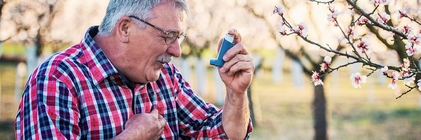 Ein Mann mit Asthma benutzt seinen Inhalator.