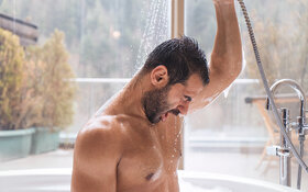 Ein Mann duscht kalt um sein Immunsystem zu stärken.