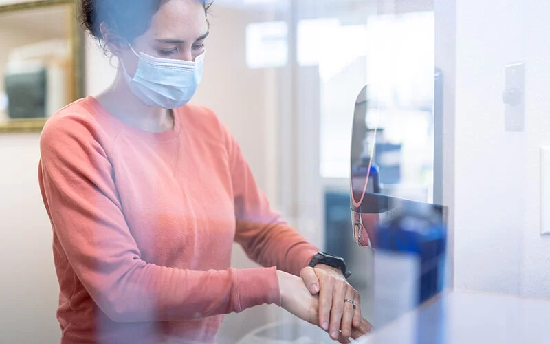 Zum Schutz vor Krankenhauskeimen desinfiziert sich eine Frau die Hände im Krankenhaus.