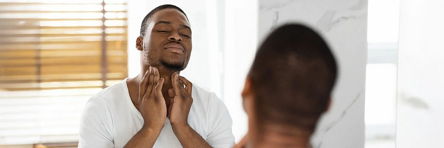 Besorgter Mann ertastet seine Lymphknoten am Hals.