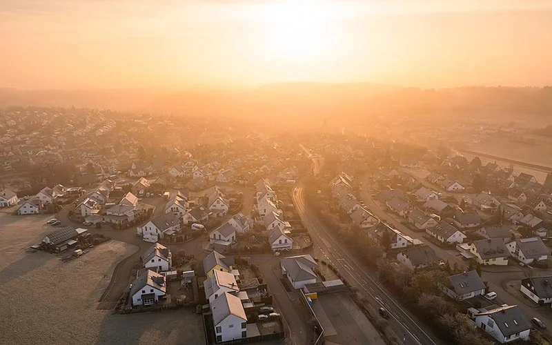 Luftaufnahme einer Wohnsiedlung in Baden-Württemberg bei tief stehender Sonne.