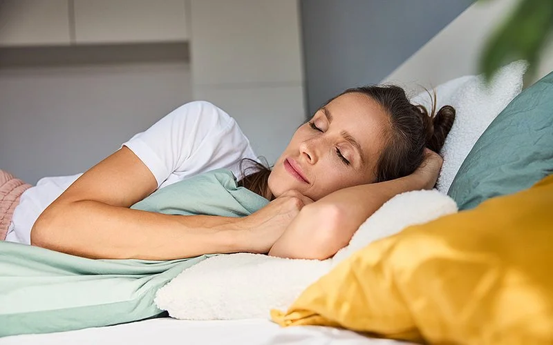 Eine Frau schläft im Bett.