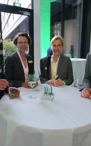 Auf dem Bild kann man Dr. Peter mit zwei Frauen und einem Mann sehen.