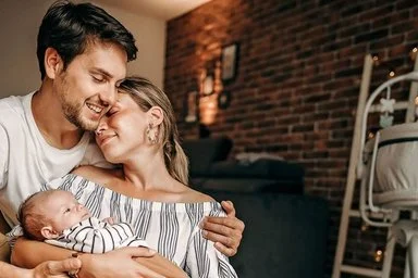 Mann hält Frau und Baby im Arm