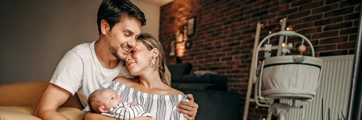 Mann hält Frau und Baby im Arm