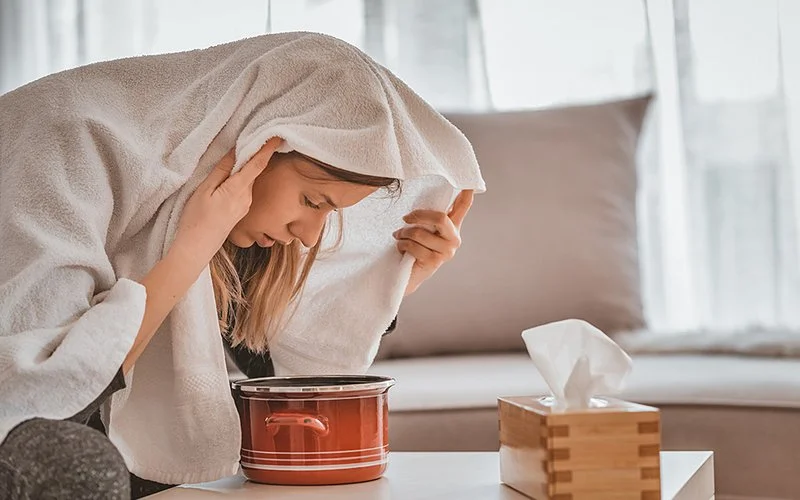 Frau hat eine Atemwegsinfektion und inhaliert. 